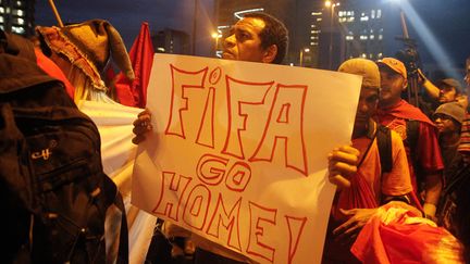 Un manifestant porte une pancarte "Fifa, rentre chez toi" dans une manifestation, &agrave; Sao Paulo, au Br&eacute;sil, jeudi 22 mai 2014.&nbsp; (AMAURI NEHN / BRAZIL PHOTO PRESS / AFP)