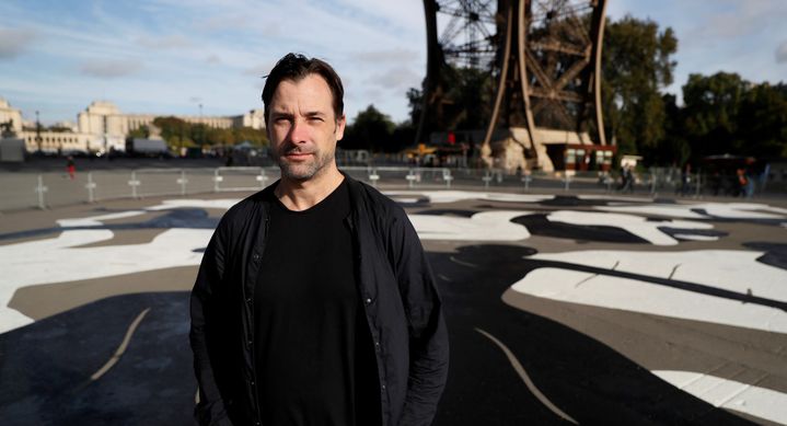 L'artiste américain Cleon Peterson devant sa fresque sur le parvis de la Tour Eiffel, le 28 septembre 2016.
 (Thomas Samson / AFP)