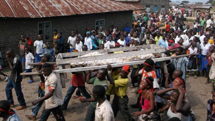 Des habitants de Beni, dans l’est de la RDC, portent sur une civière le corps d’une victime tuée par des rebelles islamistes ougandais (ADF) le 16 avril 2015. (Photo AFP/Kudra Maliro)