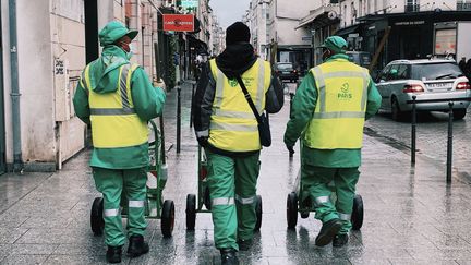 Trois éboueurs marchent rue de la Roquette à Paris, le 15 décembre 2020 (BENOIT DURAND / HANS LUCAS)