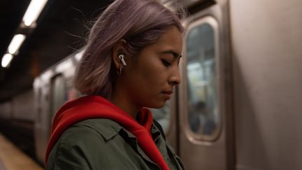 Une personne portant des oreillettes "true wireless" Airpods d'Apple.&nbsp; (APPLE)