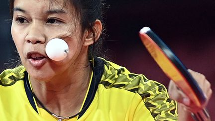 La pongiste thaïlandaise Orawan Paranang se prend une balle dans la joue au 3e tour du tournoi de tennis de table, le 26 juillet 2021 à Tokyo (Japon). (ANNE-CHRISTINE POUJOULAT / AFP)