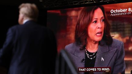 Donald Trump, avec en fond un écran diffusant des images de Kamala Harris, lors d'un meeting du candidat républicain, le 11 octobre 2024 à Reno (Nevada). (JUSTIN SULLIVAN / GETTY IMAGES NORTH AMERICA)