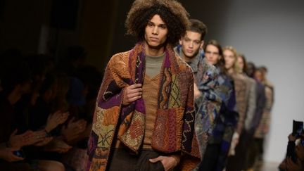 Missoni: inspirée de la vie des surfeurs, la collection se veut "proche de la nature", copiée sur le "mouvement des vagues et de la mer". D'où de grandes capes en maille multicolore, façon patchwork, un style relax et désinvolte qui se voit jusqu'aux chaussures, façon claquettes de piscine, rehaussés de fourrures. La All Star Chuck Tayler de Converse fait partie du vestiaire de ces néo-surfeurs chic, qui utilisent la fibre de lin, le cachemire ou le poil de yack pour se réchauffer. 
 (ANDREAS SOLARO / AFP)