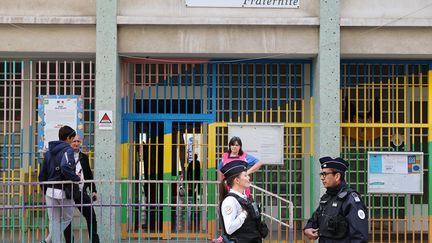 Des policiers devant une école à Nice (ARIE BOTBOL / HANS LUCAS VIA AFP)