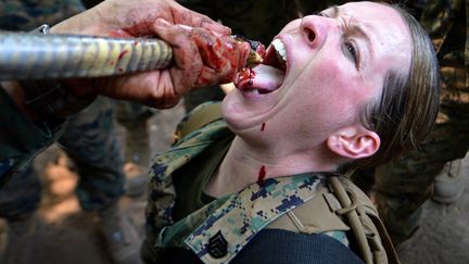 Une marine am&eacute;ricaine boit du sang de cobra lors d'un exercice de survie sur la base navale de Sattahip (Tha&iuml;lande), le 20 f&eacute;vrier 2013. (PORNCHAI KITTIWONGSAKUL / AFP)