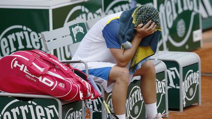 Malmen&eacute; par l'Allemand Tommy Haas, le russe&nbsp;enfouit sa t&ecirc;te sous sa serviette apr&egrave;s avoir cass&eacute; sa raquette, le 3 juin 2013 &agrave; Roland-Garros. (PATRICK KOVARIK / AFP)