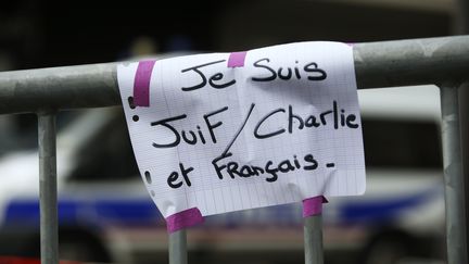 Une pancarte accroch&eacute;e sur une barri&egrave;re devant le supermarch&eacute; Hyper Cacher de la porte de Vincennes, &agrave; Paris, apr&egrave;s l'attaque qui a fait quatre morts,&nbsp;le 10 janvier 2015. (KENZO TRIBOUILLARD / AFP)