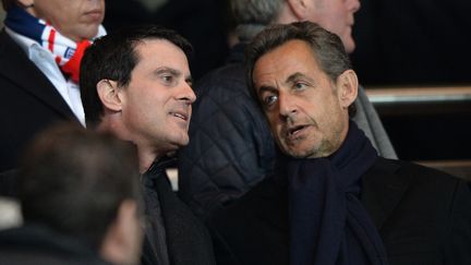 Le ministre de l'Int&eacute;rieur Manuel Valls et son pr&eacute;d&eacute;cesseur Nicolas Sarkozy, le 2 mars 2014, dans les tribunes du Parc des Princes &agrave; Paris. (MUSTAFA YALCIN / ANADOLU AGENCY / AFP)