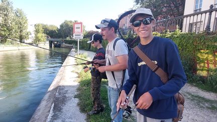 Théodore et Antonin, en pleine session pêche, avec Aurélien Fiaux au bord du canal Saint-Martin à Paris. (JULES BRELAZ / RADIOFRANCE)