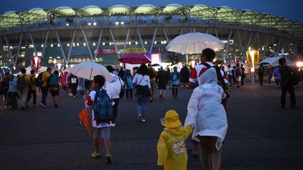 Les supporters de rugby sous la pluie, aux abords du stade&nbsp;Ecopa de Shizuoka, le 11 octobre 2019, avant le match Australie - Géorgie. (ANNE-CHRISTINE POUJOULAT / AFP)