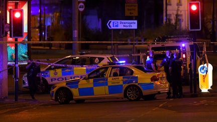 Des véhicules de police près de la Manchester Arena, une salle de concert au Royaume-Uni où une explosion a fait plusieurs morts, le 22 mai 2017. (PAUL ELLIS / AFP)