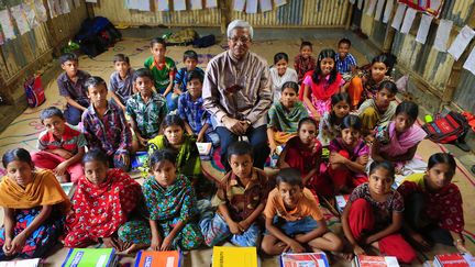 Fazle Hasan Abed, fondateur de l'ONG BRAC, avec des &eacute;tudiants de l'&eacute;cole primaire du ghetto Korail &agrave; Dacca (Bangladesh). (REZA / WEBISTAN)