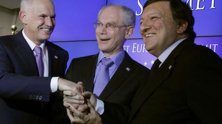 Le Premier ministre grec George Papandréou, le président du Conseil européen Herman Van Rompuy et le président de la Commission européenne José Manuel Barroso se félicitent mutuellement après un la signature d'un plan de sauvetage pour la Grèce, le 21 juillet 2011 à Bruxelles (Belgique).&nbsp;D'importantes mesures d'austérité ont été prises par Athènes pour répondre à la&nbsp;crise de la dette qui menaçait l'avenir du pays. (VIRGINIA MAYO / AP / SIPA)