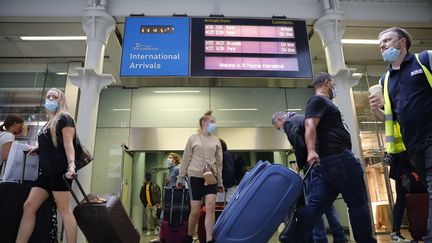 Des passagers en provenance de Paris, portant des masques, arrivent à la gare internationale de Saint-Pancras à Londres le vendredi 14 août 2020. (TOLGA AKMEN / AFP)