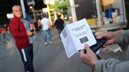 Un homme montre son certificat de vaccination à Charleroi, en Belgique, le 13 août 2021. (BRUNO FAHY / BELGA)