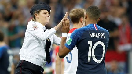 Kylian Mbappé tape dans les mains d'une membre des Pussy Riot qui s'était introduite sur le terrain, ce qui n'était pas la seule image étonnante de la finale de la Coupe du Monde, le 15 juillet 2018 à Moscou. (DARREN STAPLES / REUTERS)