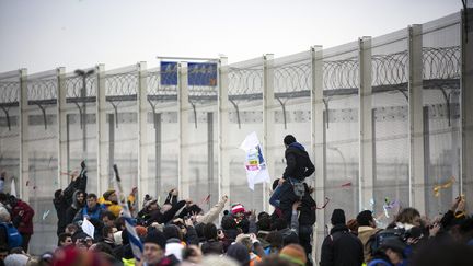  (Des manifestants devant le nouveau "mur" qui entoure les embarcadères du port de Calais © Maxppp)