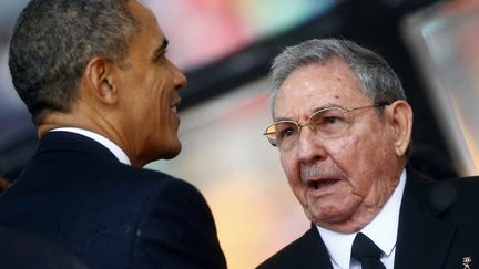 Barack Obama salue le pr&eacute;sident cubain Raul Castro, le 10 d&eacute;cembre 2013, lors de l'hommage &agrave; Nelson Mandela &agrave; Johannesbourg.&nbsp; (KAI PFAFFENBACH / REUTERS)