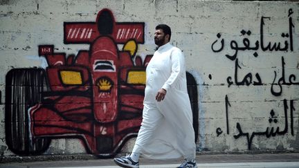 Un Bahre&iuml;nien passe devant un tag demandant : "Allez vous courir sur le sang des martyrs ?", le 9 avril 2012, &agrave; Barbar (Bahre&iuml;n). (STR / AFP)