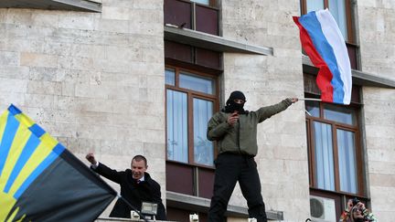 Un manifestant pro-Moscou brandit un drapeau russe lors de l'occupation d'un b&acirc;timent officiel &agrave; Donetsk (Ukraine), le 6 avril 2014. (ALEXANDER KHUDOTEPLY / AFP)