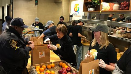 Un poilicier, comme d'autres fonctionnaires américains, vient chercher un repas gratuit&nbsp;offert, le 16 janvier 2019, à Washington, par l'association du cuisinier, Jose Andres. (GREGORY PHILIPPS / RADIO FRANCE)