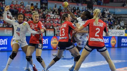 La Française&nbsp;Meline Nocandy prise dans la défense norvégienne, comme la pivot Pauletta Foppa, lors de la finale du championnat du monde de hand France-Norvège, le 19 décembre 2021 à Granollers. (PAU BARRENA / AFP)