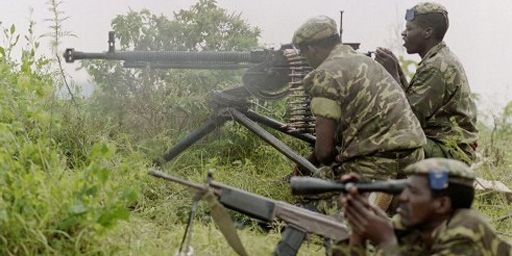 Soldats de l'armée gouvernementale rwandaise tirant sur des positions rebelles le 12 juin 1994 (AFP - Alexander Joe)