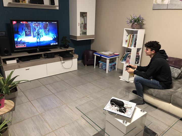 A&nbsp;Anzeling, Jordan, 18 ans, profite d'un peu de connexion internet pour jouer à la console. (ALIENOR VINCOTTE / FRANCEINFO)