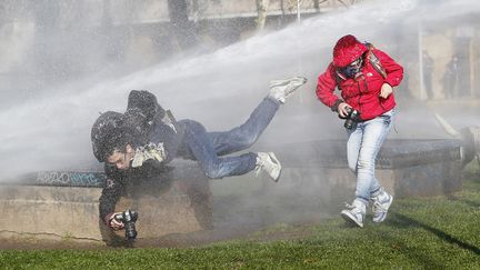 Un photographe est frapp&eacute; par le jet d'un canon &agrave; eau tir&eacute; par un v&eacute;hicule de la police lors d'une manifestation &agrave; Santiago (Chili), le 11 juillet 2013. (IVAN ALVARADO / REUTERS)