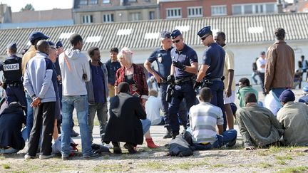 Des policiers fran&ccedil;ais parlent avec des migrants &agrave; Calais (Pas-de-Calais), le 5 ao&ucirc;t 2014. (FRANCOIS LO PRESTI / AFP)