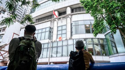 Des journalistes photographient le bureau chinois de défense de la sécurité nationale à Hong Kong, le 8 juillet 2020. (ANTHONY WALLACE / AFP)