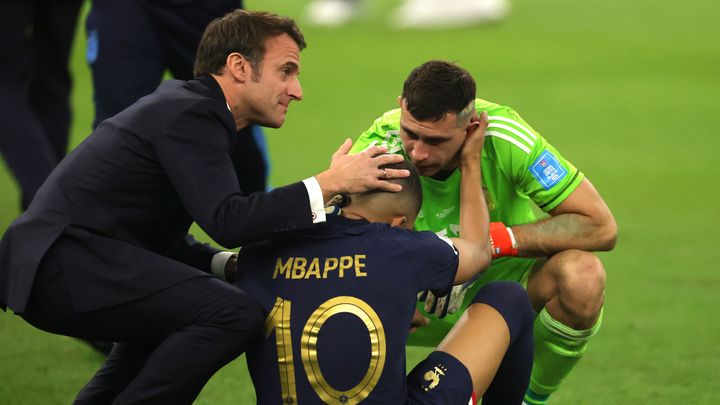 Le président français Emmanuel Macron, l'attaquant français Kylian Mbappé, et le gardien argentin Emiliano Martinez, après la défaite de la France en finale de la Coupe du monde face à l'Argentine, le 18 décembre 2022. (MAXPPP)