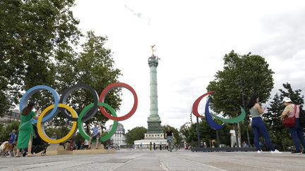 Les anneaux olympiques à côté des Agitos, le symbole des Jeux paralympiques, sur la place de la Bastille, à Paris, le 21 juillet 2024. (CHINA NEWS SERVICE / GETTY IMAGES)