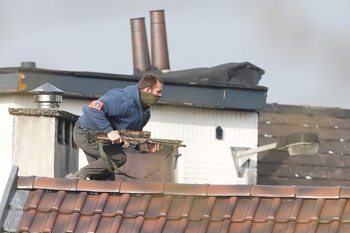 Un policier sur un toit, rue du Dries, à Forest (Bruxelles), où a&nbsp;éclaté une fusillade lors d'une perquisition, le&nbsp;15 mars 2016.&nbsp; (MAXPPP)