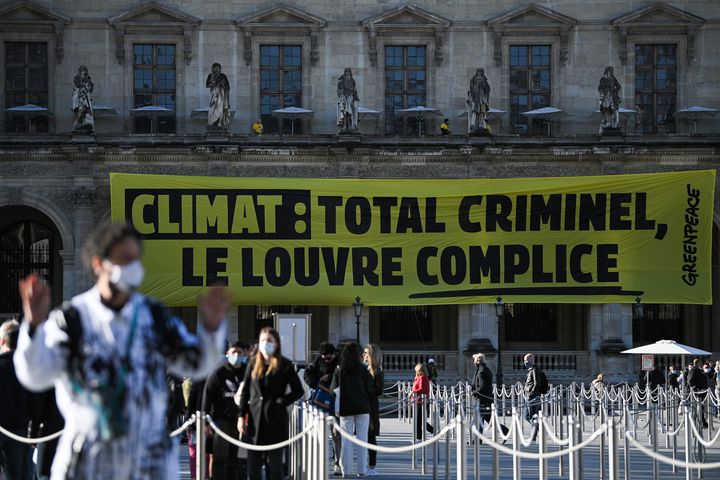 Des militants de Greenpeace ont déployé une banderole de 27 mètres de long pour dénoncer le partenariat entre le Louvre et TotalEnergies, le 6 octobre 2021.&nbsp;&nbsp; (ANNE-CHRISTINE POUJOULAT / AFP)