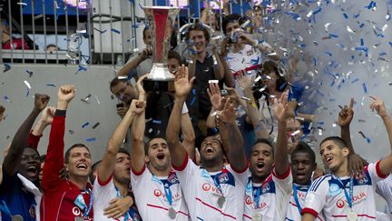 Les joueurs de l'Olympique Lyonnais brandissent le Troph&eacute;e des champions, apr&egrave;s leur victoire face &agrave; Montpellier, samedi 28 juillet &agrave; Harrison (New-Jersey). (DON EMMERT / AFP)