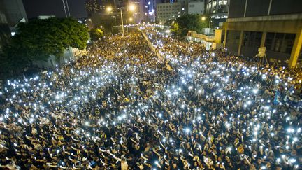 Des milliers de manifestants brandissent leur téléphone portable devant le siège du Conseil législatif&nbsp;de Hong Kong, le 29 septembre 2014, pour demander à Pékin d'accorder aux citoyens du territoire autonome le suffrage universel total. (XAUME OLLEROS / AFP)