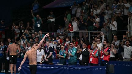 Après la démonstration, place à la communion. Deux heures seulement après son titre acquis de haute lutte sur le 200 m papillon, Léon Marchand a remporté sa deuxième médaille d'or de la soirée - sa troisième depuis le début des Jeux - en finale du 200 m brasse. Ovationné par le public de Paris La Défense Arena, le jeune homme de 22 ans, tout sourire, pouvait remercier ce soutien sans faille. (MANAN VATSYAYANA / AFP)