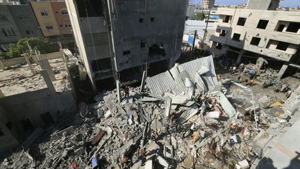 Des Palestiniens cherchent des victimes dans les décombres d'un bâtiment après une frappe israélienne dans le sud de la bande de Gaza, le 17 octobre 2023. (MAHMUD HAMS / AFP)