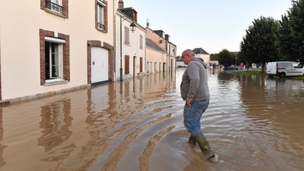 Un homme marche dans une rue à Bonneval (Eure-et-Loir), le 10 octobre 2024, après le passage de la dépression Kirk. (JEAN-FRANCOIS MONIER / AFP)