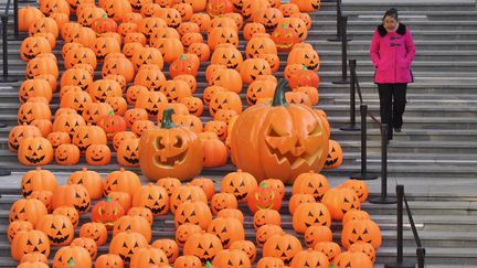 Une femme descend un escalier chargé de citrouilles, à Shenyang, en Chine, vendredi 30 octobre 2015.&nbsp; (REUTERS)