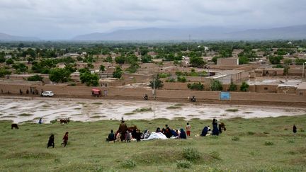 Des Afghan regroupés sur une colline après avoir fui leurs maisons envahies par la boue lors d'une crue, dans un village de la province de Baghlan (Afghanistan), le 11 mai 2024. (ATIF ARYAN / AFP)