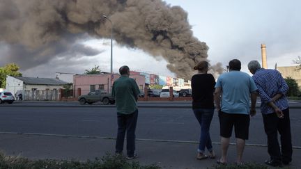 Des habitants d'Odessa (Ukraine), observe la fumée qui se dégage après un tir de missile, le 16 juillet 2022. (OLEKSANDR GIMANOV / AFP)