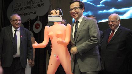 Le ministre chilien de l'Economie,&nbsp;Luis Felipe Céspedes, pose avec une poupée gonflable lors d'un dîner à Santiago, le 13 décembre 2016.&nbsp; (GEORGE CADENAS / AFP)