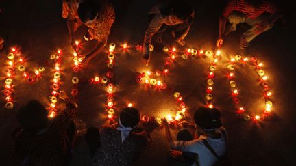 Le nom du vol MH370 dessin&eacute; avec des bougies, lors d'une c&eacute;r&eacute;monie&nbsp;bouddhiste &agrave;&nbsp;Phnom Penh (Cambodge), le 17 mars 2014. (PRING SAMRANG / REUTERS )