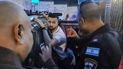 Image extraite d'une vidéo montrant un gendarme français interpellé par des policiers israéliens, le 7 novembre, dans le domaine français d'Éléona, à Jérusalem. (CHLOE ROUVEYROLLES-BAZIRE / AFP)