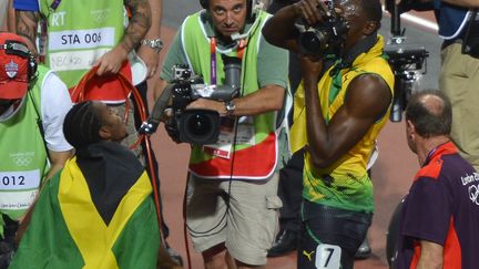 Apr&egrave;s sa victoire au 200 m, Usain Bolt&nbsp;a pris l'appareil photo d'un photographe pour immortaliser tout ce qui pouvait l'&ecirc;tre, comme son comp&egrave;re et ami Yohan Blake, qui a pris la m&eacute;daille d'argent (ODD ANDERSEN / AFP)