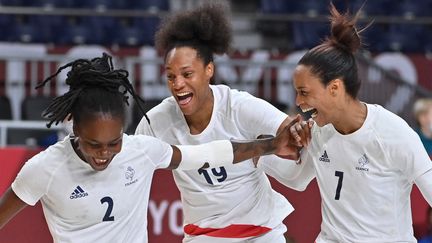 Meline Nocandy (à gauche), Oceane Sercien Ugolin (au centre) et Allison Pineau (à droite) après la victoire de l'équipe de France de handball en demi-finale des Jeux olympiques de Tokyo.&nbsp; (FABRICE COFFRINI / AFP)