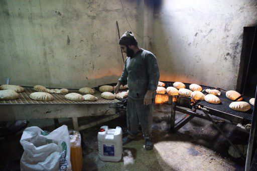 Dans une boulangerie installée par la direction des Affaires religieuses turques dans la province d'Idlib, où les prix des denrées de première nécessité ont flambé, pour subvenir aux besoins des nouveaux arrivants d'Alep, le 24 décembre 2016. (Cem Genco/Anadolu Agency/AFP )